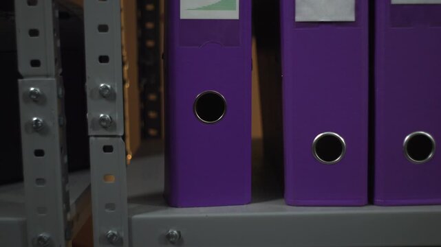 Purple ring binders on office shelf