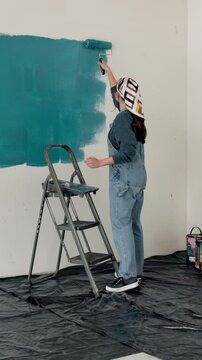 Woman, ladder and painting wall with brush for creativity, self expression and interior design. Process, person and home decor with diy project, remodelling and paint for renovation and inspiration