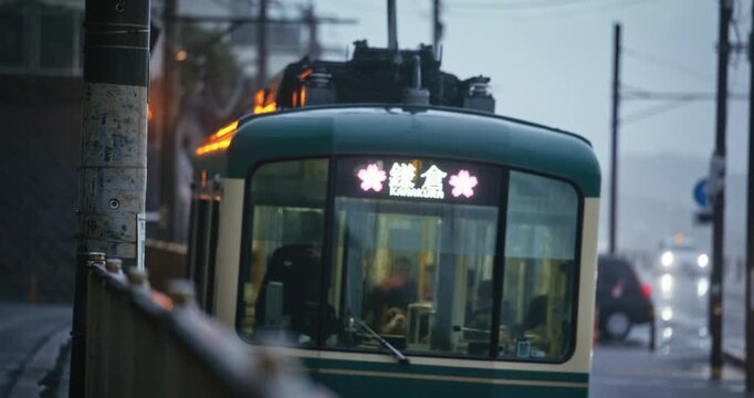 Closeup of slow moving train passing by near road during rain storm