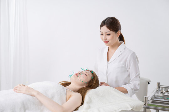美容鍼灸する女性と鍼灸師