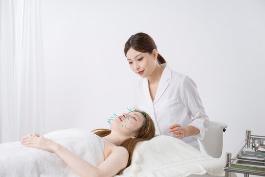 美容鍼灸する女性と鍼灸師