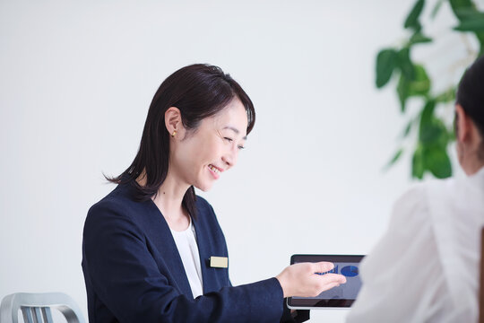 タブレット端末を使い接客をする女性