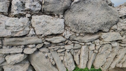 Fototapeta premium Detailed macro shot focusing on the weathered rocks, traditional mortar, and historic masonry structure of an old stone aqueduct wall.
