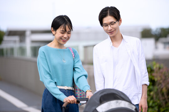 ベビーカーの子供を見る夫婦