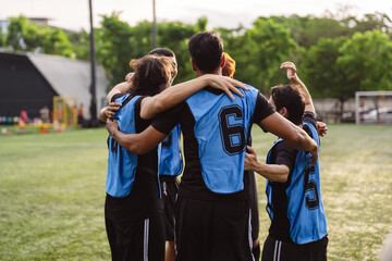 Naklejka premium Excited soccer players hugging and celebrating a victory on the field. Teamwork, bonding, and success concept during a sports match.