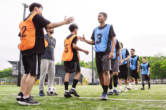 Soccer players shaking hands in a line to show sportsmanship and respect after a match. Teamwork and fair play concept in sports.
