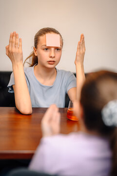 Teen girl playing guessing game with sticky note