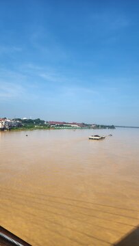 A river with brown water, polluted by environmentally damaging mining activities.