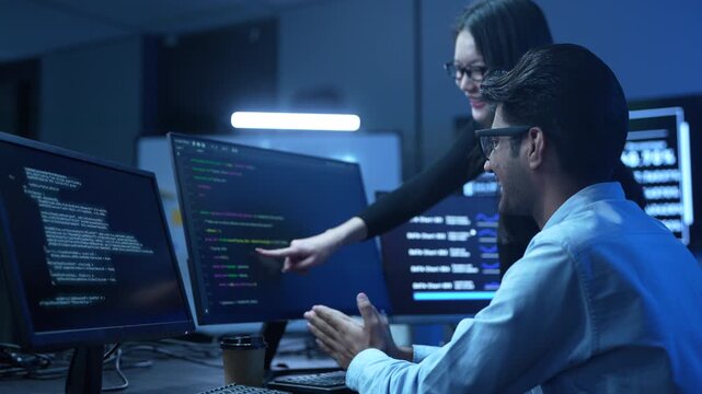 Professional IT specialist and programmer working on software development, Male developer talking with female colleague about computer code, Modern coding team and technology collaboration concept