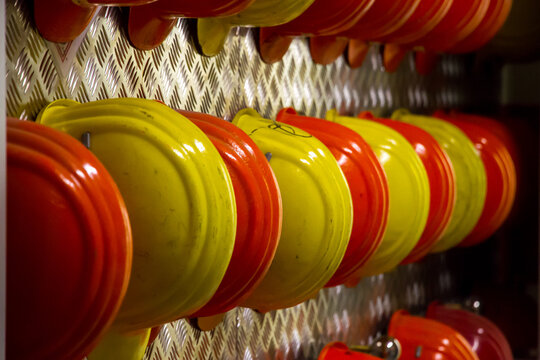 Red and yellow fire helmets on a metallic diamond plate wall