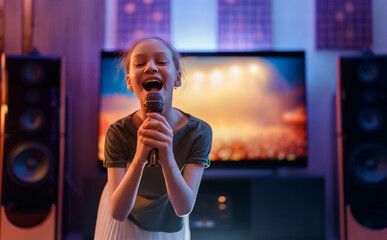 Joyful Young Girl Singing Karaoke at Home Entertainment System with Microphone © Konstantin Yuganov