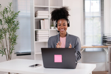 Fototapeta premium African american woman wearing headset and mic communicating with client, providing online customer support, joining a virtual meeting, or working as a call center agent from home office