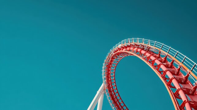 Roller coaster loop against blue sky.