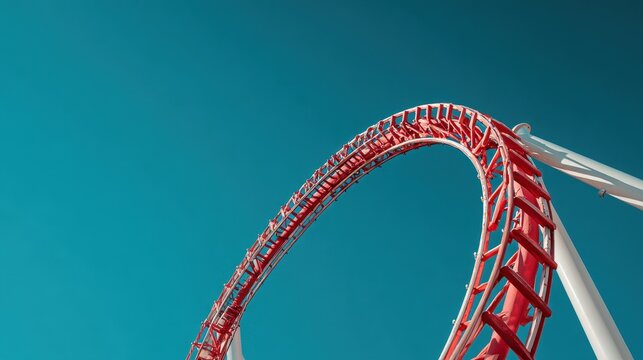 Roller coaster loop against blue sky.