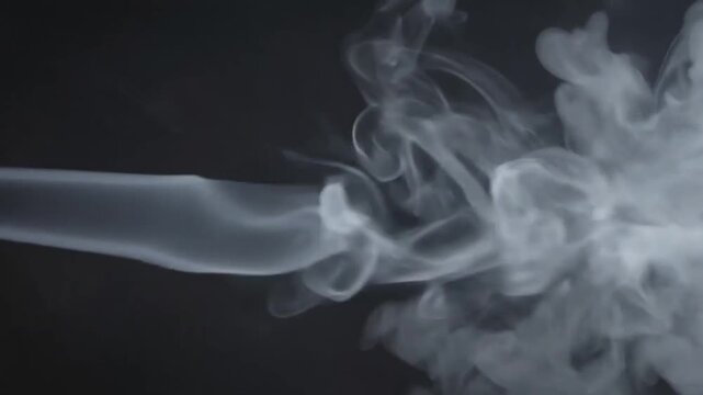 Wisps of white smoke or vapor swirling and drifting against a dark gray background, creating an ethereal and atmospheric effect, abstract, white, smoke, vapor, swirling, drifting, dark, gray