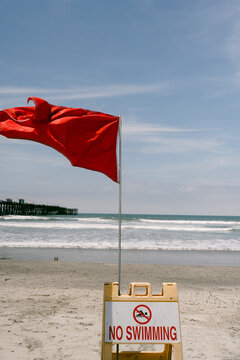 Red flag and no swimming sign on beach