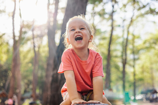 Joyful toddler laughing with delight in a sunny forest