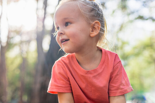 Curious little girl looking off camera outside