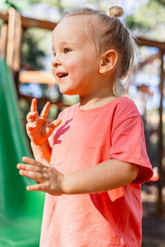 Happy toddler girl plays at an outdoor playground