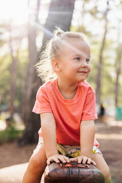 Cute toddler with blonde hair smiling outdoors