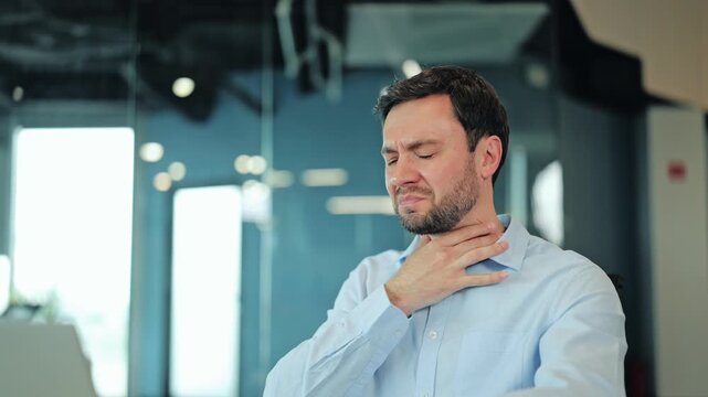 Close-up of sick corporate worker or freelance designer touching sore throat at laptop. Exhausted manager or IT specialist suffering from sudden cold, flu or respiratory illness at computer desk