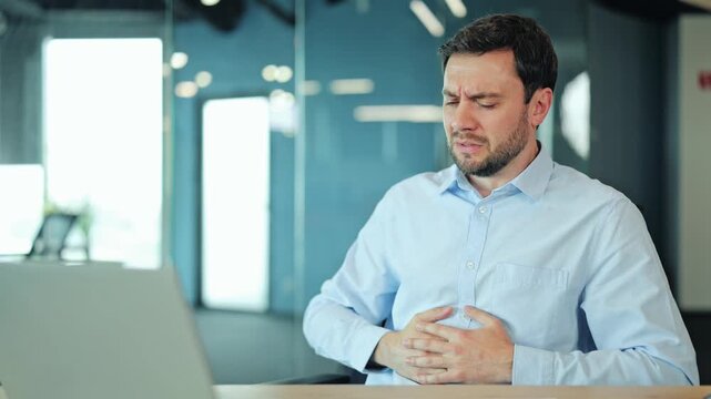 Corporate worker or freelance designer having sudden abdominal pain, indigestion or nausea at laptop. Exhausted manager or IT specialist feeling bad health problem, sickness or spasm at desk