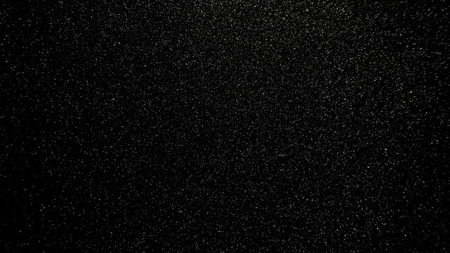 fine sparkling silver glitter texture shimmering over deep black background with cosmic night sky atmosphere
