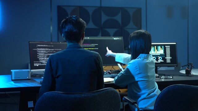 Professional IT specialist and programmer working on software development, Male developer talking with female colleague about computer code, Modern coding team and technology collaboration concept