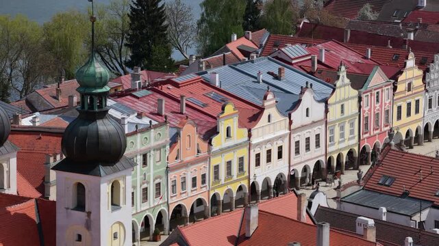 Aerial drone view of colorful pastel-hued Renaissance arcaded townhouses with ornate gables lining the historic main square of a Czech heritage town, Telc, Czech Republic