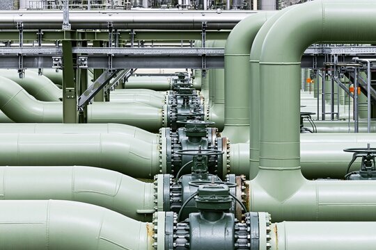 Industrial steel pipeline and valve assembly for energy processing, chemical plant management and factory infrastructure maintenance with weathered green metal pipe surfaces