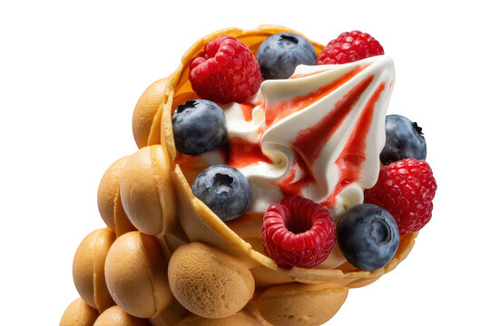 A bubble waffle cone filled with soft serve vanilla ice cream, topped with fresh raspberries, blueberries, and a drizzle of red fruit syrup sauce