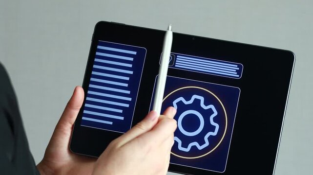 A person uses a tablet to manage digital files and settings. The screen shows documents and a gear icon. The setting is indoors with plain background.