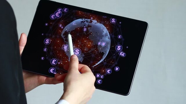 A person holds a tablet and stylus, drawing a 3D globe covered with various symbols. The location is a simple indoor space. The activity shows creativity and technology.