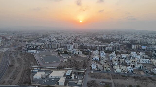 Muscat, Oman. Aerial drone view at sunset of the capital of Oman. Flight over the Mohammed Al Amin Mosque at sunrise or sunset. Flight over the sleeping city in the morning light.