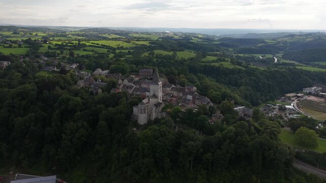Beautiful aerial view showing the historic medieval village of limbourg in belgium, with its famous saint george's church surrounded by lush green forests and rolling hills in the background