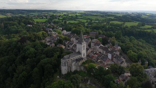 Picturesque aerial view revealing the historic village of limbourg, a medieval settlement with saint george's church nestled atop a hill and surrounded by lush green forests and rolling countryside