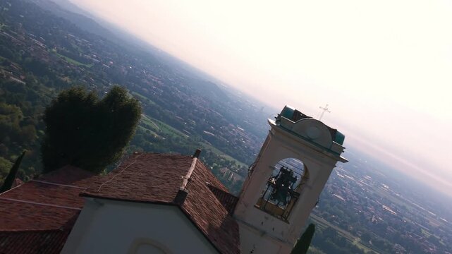 Montevecchia Sanctuary standing on a hill overlooking the Italian landscape and valley. aerial view, push forward, rotating shot