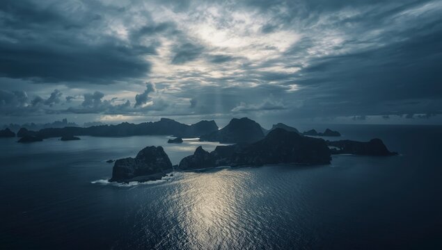 Atardecer en la playa con cielo iluminado sobre el oc&eacute;ano, la costa, rocas e islas en un paisaje natural de verano con horizonte tranquilo