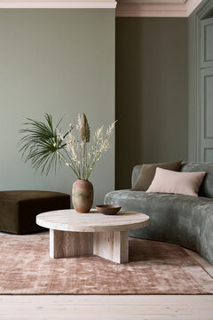 Colorful living room featuring a green sofa, round wooden coffee table, decorative vase, and stylish decor elements in a modern interior setting