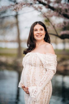 Pregnant woman smiling enjoying spring nature maternity photoshoot