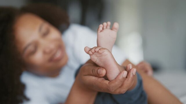 Closeup of cute little feet of african infant in mother hands, happy moments. Family time, young adult black woman spending weekend with her baby daughter or son, adopted child in family, start life