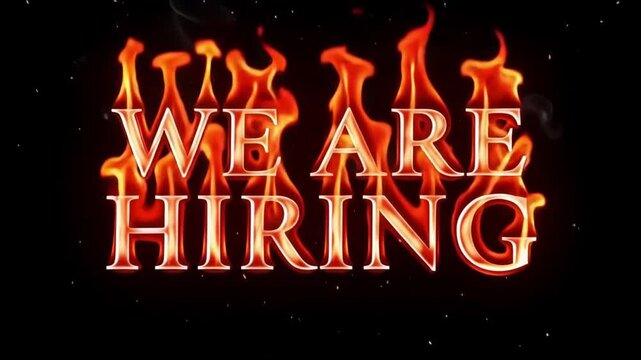 We are hiring text displayed in bold white letters engulfed by intense dancing orange flames and rising smoke in this dynamic motion graphics animation clip designed for professional corporate job rec
