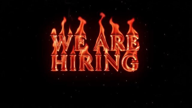 We are hiring text written in bright orange flames with realistic rising smoke and floating embers against a solid black background creating an intense cinematic motion video footage animation for cor