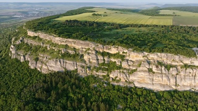 Madara Rocks aerial wide angle limestone escarpment Bulgaria green forest fields panorama drone UNESCO landmark Shumen region nature landscape slow motion Balkans summer overview travel