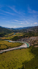 Naklejka premium drone view showcasing the sweeping curves of the Vjosa river beneath the majestic Nemërçka mountain peaks near Këlcyrë, Albania