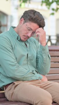 Man Feeling Worried While Sitting on Bench Outdoor, vertical video