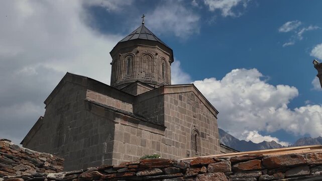 Old church in Georgia with dome outside against background of sky with clouds.