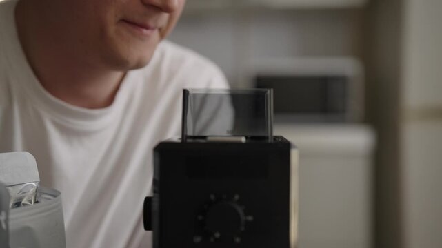 Professional barista measuring and grinding fresh coffee beans, smelling rich aroma before brewing espresso, capturing artisanal process of specialty coffee making. Shooting in slow motion