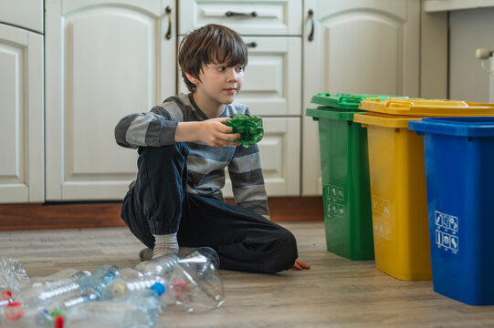 Boy sorting plastic waste for recycling indoors