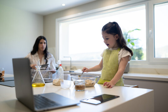 Mother and daughter bonding while baking in home kitchen